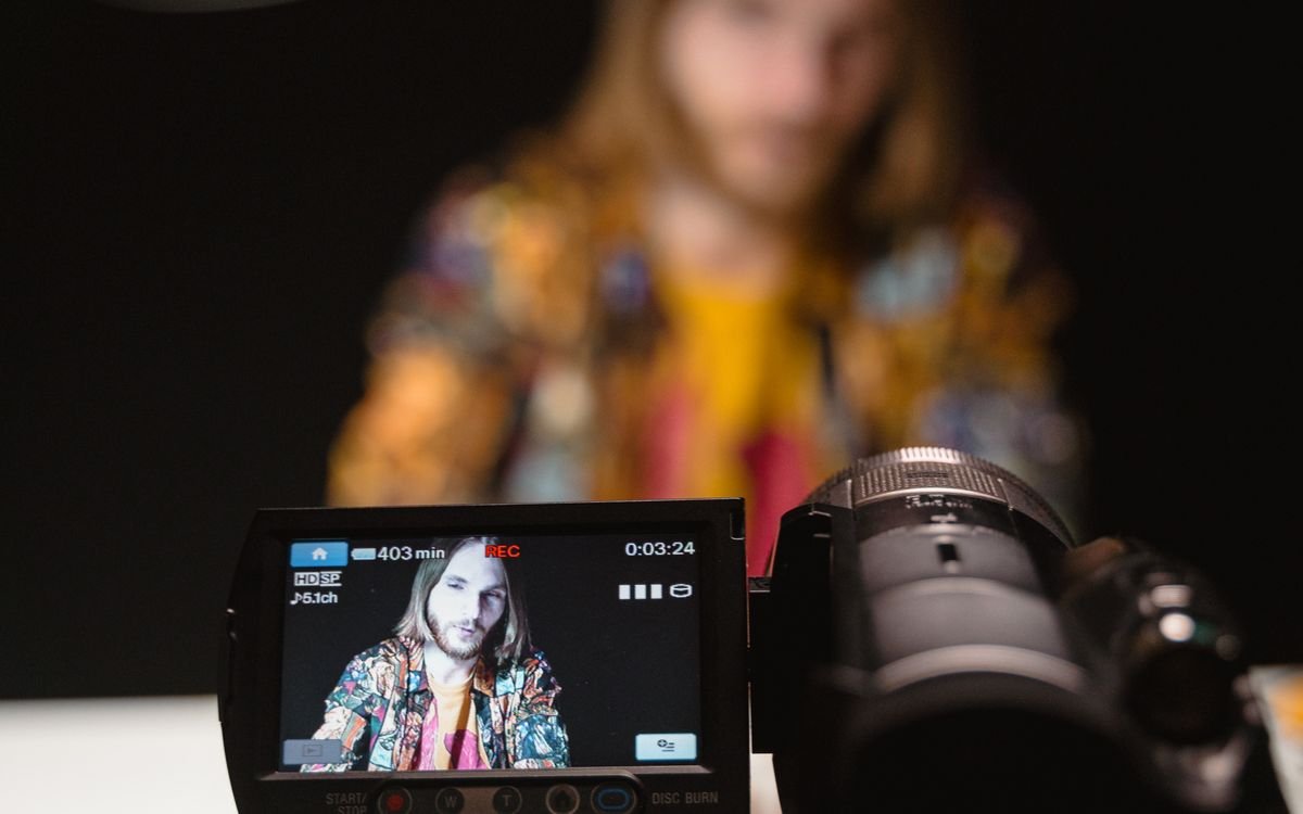Formador grabando una lección frente a cámara en un set iluminado